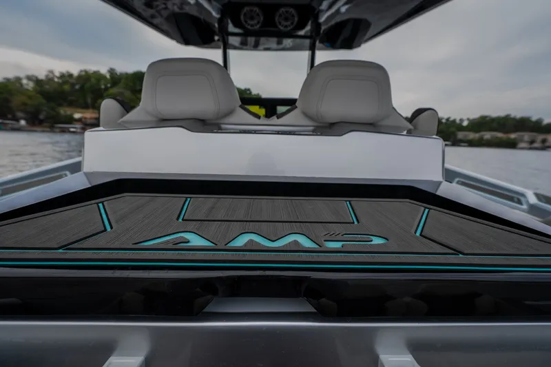 Slide: The Image of 2025 AMP 333 CC boat interior with sleek design and modern seating on a lake. - 41