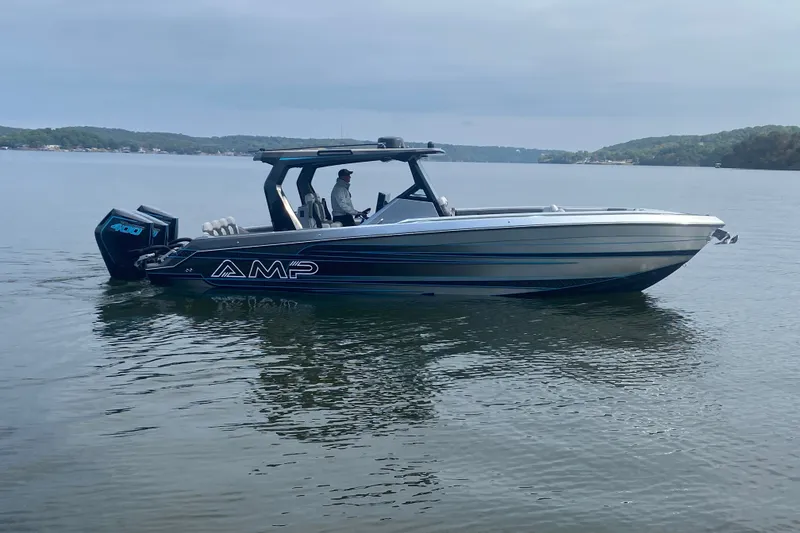 Slide: The Image of 2025 AMP 333 CC boat on calm lake with scenic background. - 6