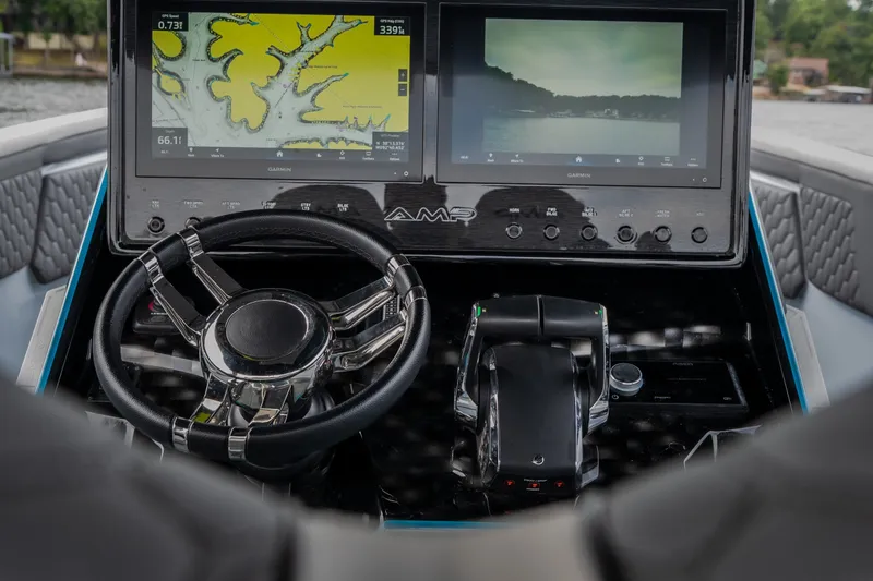 Slide: The Image of Steering console of 2025 AMP 333 CC boat with dual navigation screens. - 46