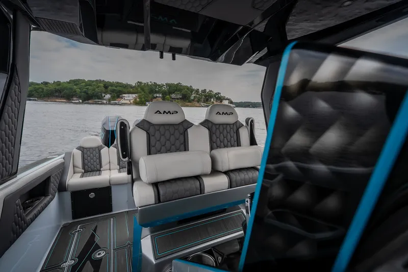 Slide: The Image of Luxurious interior of 2025 AMP 333 CC boat with plush seating on a serene lake. - 51