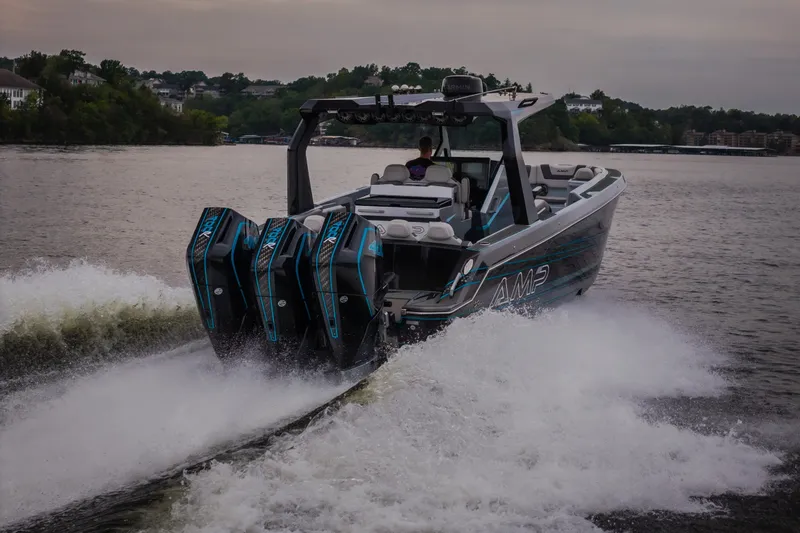 Slide: The Image of 2025 AMP 333 CC boat cruising on a lake with powerful engines. - 78