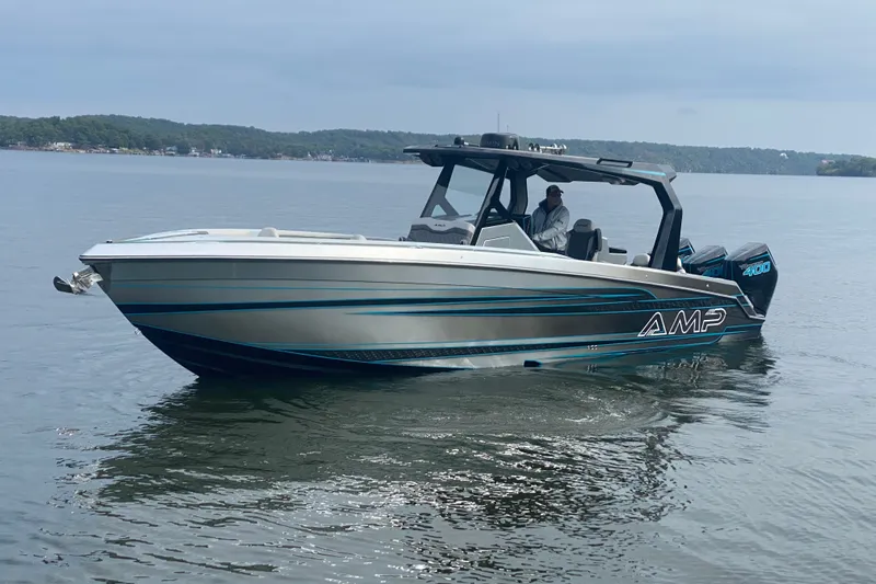 Slide: The Image of 2025 AMP 333 CC boat on calm lake waters, featuring sleek design and modern technology. - 7