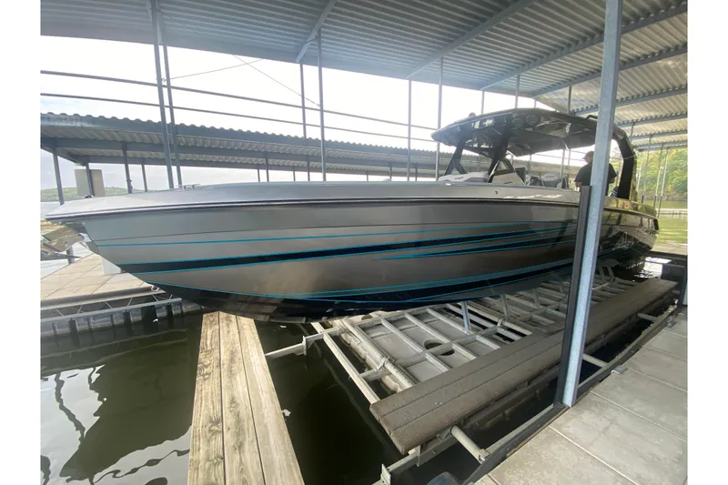 Slide: The Image of 2025 AMP 333 CC boat docked in a covered marina, side view. - 11