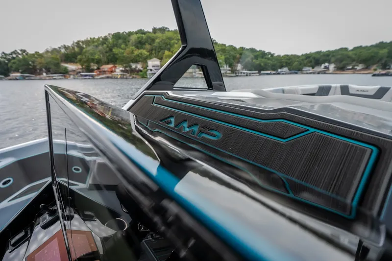 Slide: The Image of 2025 AMP 333 CC boat dashboard with sleek design on a scenic lake. - 58