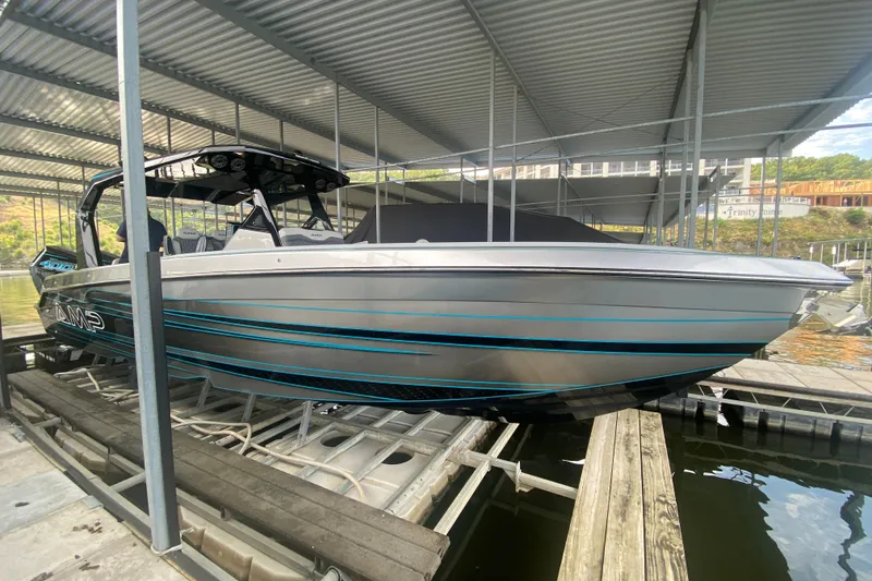 Slide: The Image of 2025 AMP 333 CC boat docked under a metal canopy, showcasing sleek design and modern features. - 10