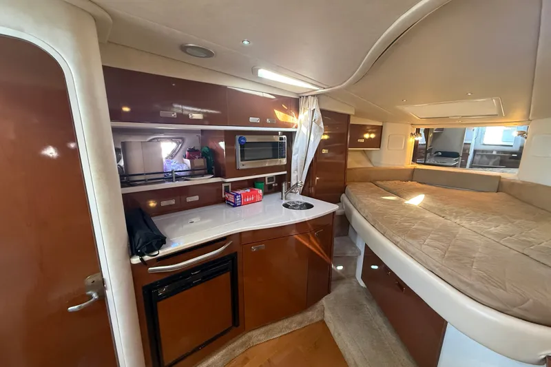 Slide: The Image of 2010 Sea Ray Sundancer 330 interior with kitchenette and cozy sleeping area. - 17