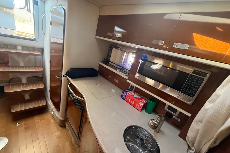 Slide: The Image of Interior of 2010 Sea Ray Sundancer 330 yacht with kitchenette and wooden stairs. - 16