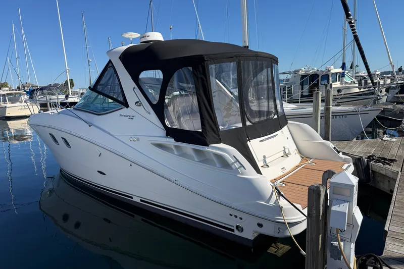 The Image of 2010 Sea Ray Sundancer 330 yacht docked at marina under clear blue sky. - 0