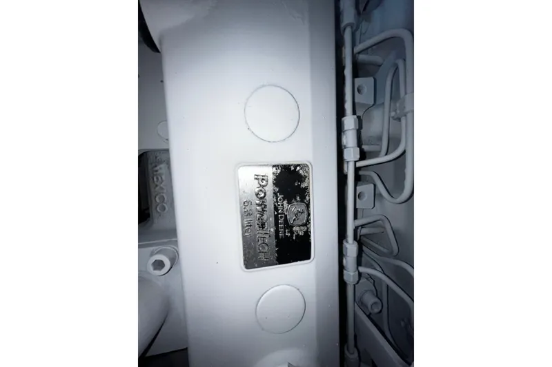 Slide: The Image of Close-up of a 2007 Progressive Industrial engine component with visible metal plate and tubing. - 27