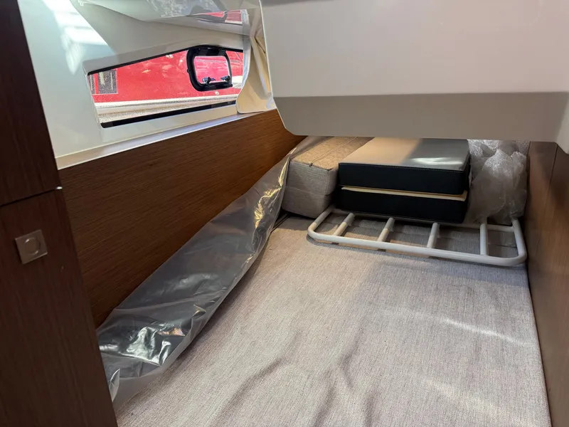 Slide: The Image of Interior of the 2024 Jeanneau NC 1095 Coupe with wood paneling and a window. - 22