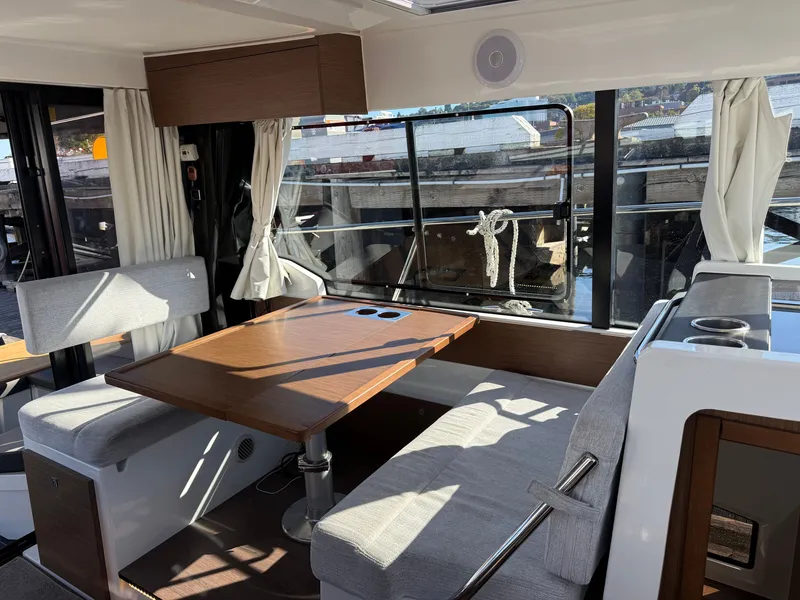 Slide: The Image of Interior of the 2024 Jeanneau NC 1095 Coupe with cozy seating area and large windows. - 19
