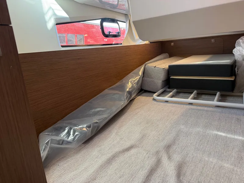 Slide: The Image of Interior of a 2024 Jeanneau NC 1095 Coupe with wood paneling and cushioned seating. - 26