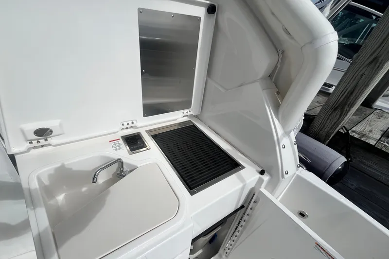 Slide: The Image of 2027 Pursuit DC 326 Dual Console boat interior with sink and grill station. - 2