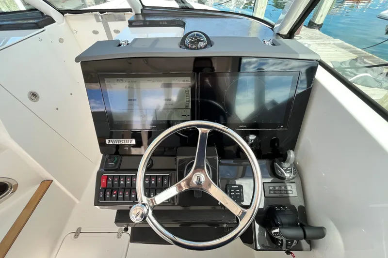 Slide: The Image of 2027 Pursuit DC 326 Dual Console helm with steering wheel and navigation display. - 14