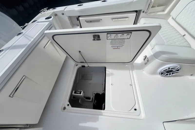 Slide: The Image of 2027 Pursuit DC 326 Dual Console boat with open storage compartment and seating area. - 5