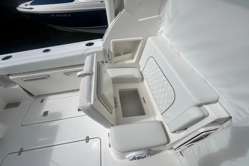 Slide: The Image of 2027 Pursuit DC 326 Dual Console boat interior with white seating and storage compartments. - 8