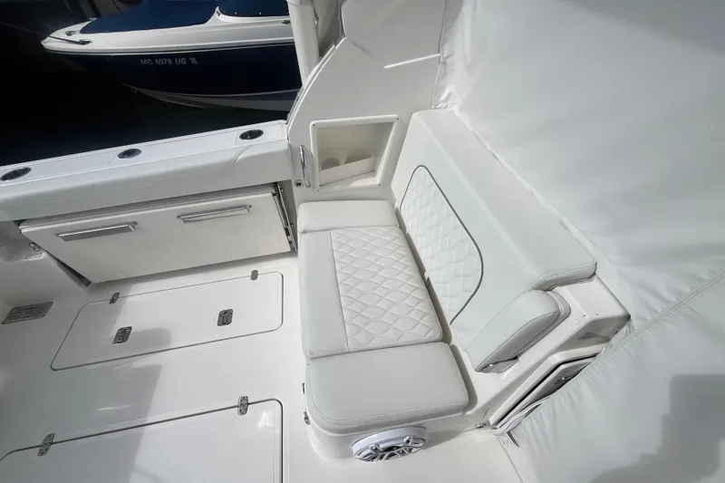 Slide: The Image of 2027 Pursuit DC 326 Dual Console boat interior with white seating and storage compartments. - 9