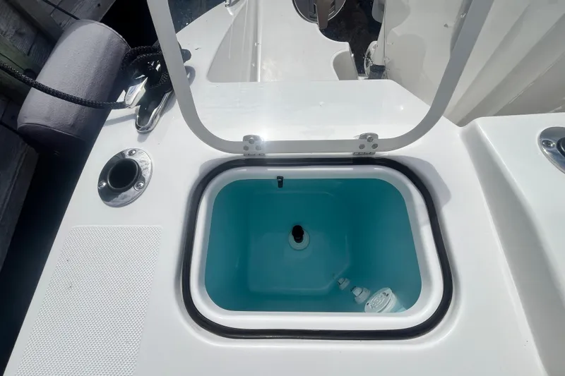 Slide: The Image of Livewell on 2027 Pursuit DC 326 Dual Console boat, open lid, blue interior. - 7
