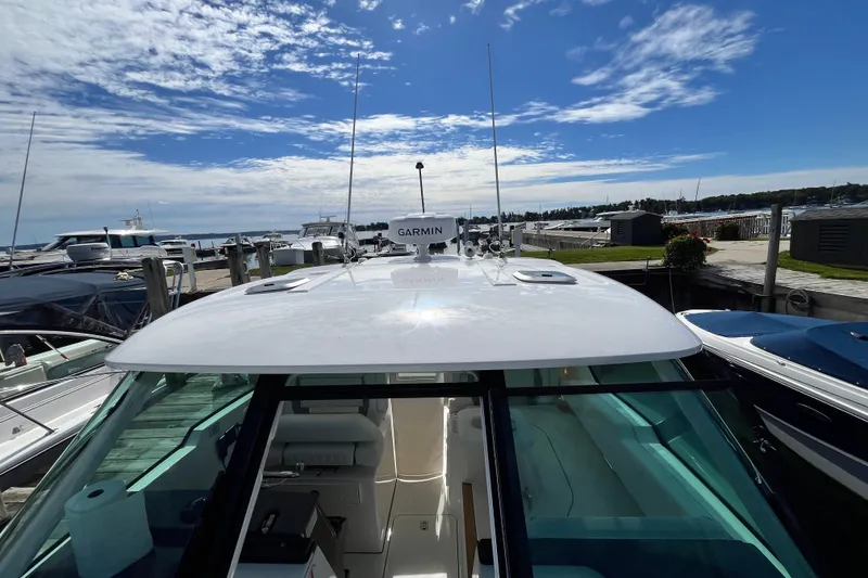 Slide: The Image of 2027 Pursuit DC 326 Dual Console boat docked under a clear blue sky. - 24