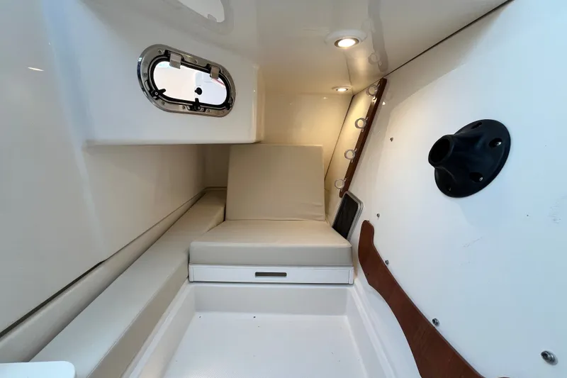 Slide: The Image of Interior cabin of 2027 Pursuit DC 326 Dual Console boat, featuring seating and porthole. - 19