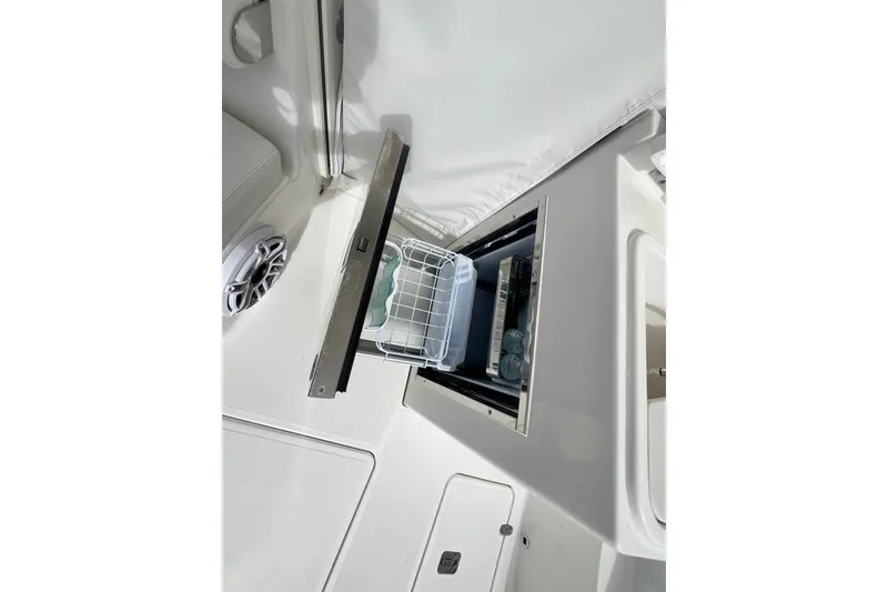 Slide: The Image of Open storage compartment on 2027 Pursuit DC 326 Dual Console boat interior. - 10