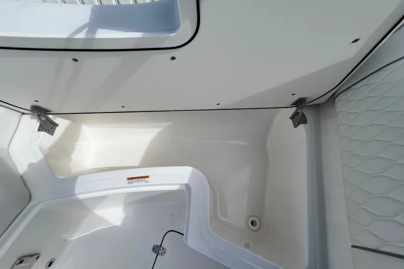 Slide: The Image of Close-up of a white boat interior with cushioned seating and storage space. - 26