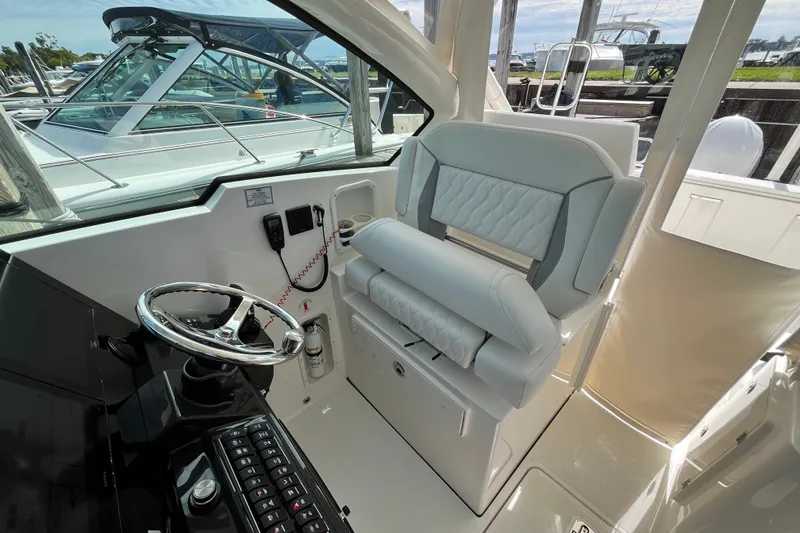 Slide: The Image of 2027 Pursuit DC 326 Dual Console helm with luxurious seating and modern controls. - 12