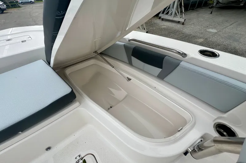 Slide: The Image of Open storage compartment on 2027 Robalo 226 Cayman boat, featuring cushioned seating. - 17