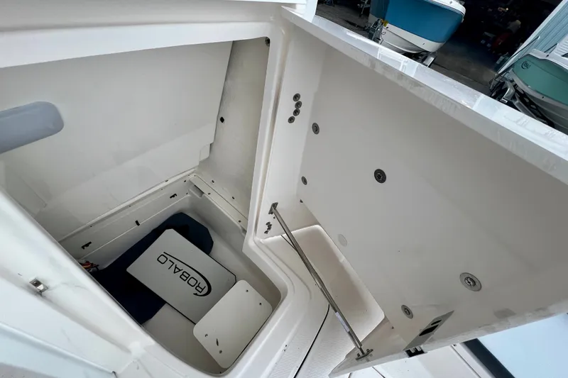 Slide: The Image of 2027 Robalo 226 Cayman boat storage compartment with open hatch, showcasing interior space. - 16