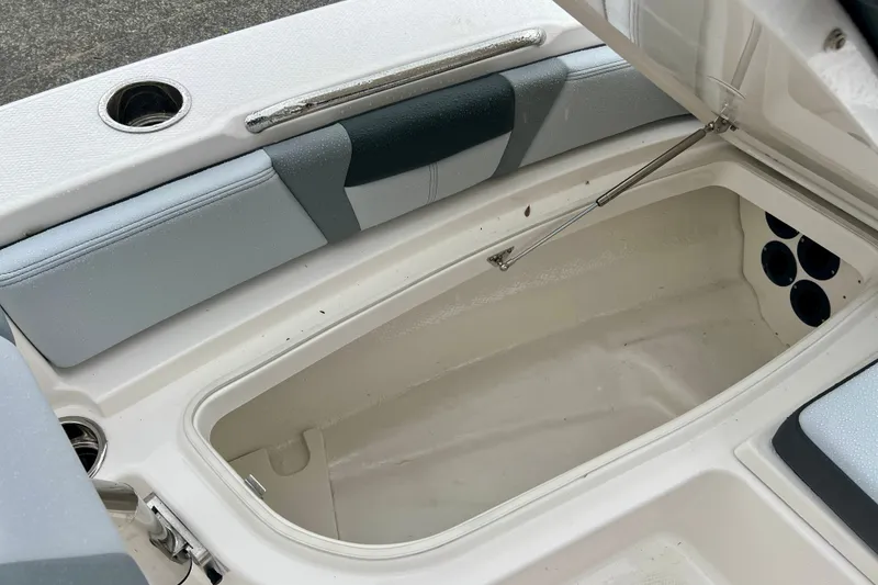 Slide: The Image of Open storage compartment on 2027 Robalo 226 Cayman boat, featuring cushioned seating. - 18