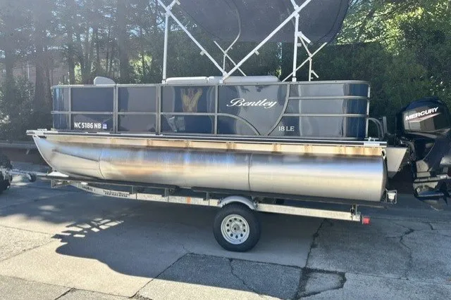 Slide: The Image of 2023 Bentley 180 LE pontoon boat on trailer, parked outdoors. - 1