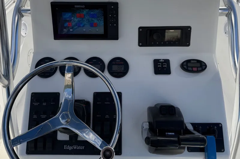 Slide: The Image of Edgewater 245CC 2005 boat dashboard with steering wheel and navigation controls. - 3