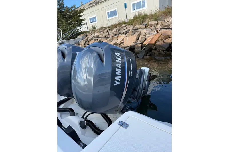 Slide: The Image of Twin Yamaha outboard engines on a 2005 Edgewater 245CC boat near rocky shoreline. - 12
