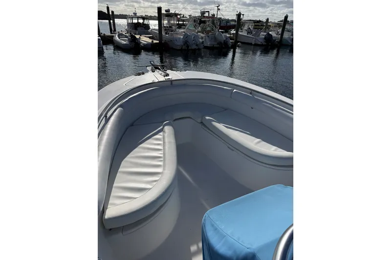 Slide: The Image of 2005 Edgewater 245CC boat interior with white seating, docked at marina. - 1