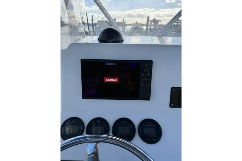 Slide: The Image of Dashboard of a 2005 Edgewater 245CC boat with Simrad display and gauges. - 4