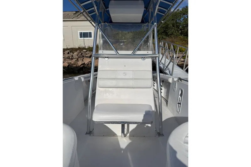 Slide: The Image of 2005 Edgewater 245CC boat interior with white seating and metal frame. - 2