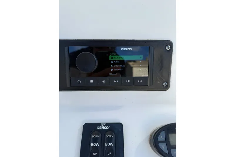 Slide: The Image of Fusion audio system and Lenco controls on a 2005 Edgewater 245CC boat dashboard. - 5