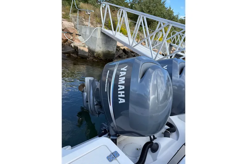 Slide: The Image of Twin Yamaha outboard motors on a 2005 Edgewater 245CC boat docked by a pier. - 13