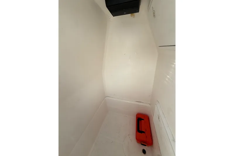 Slide: The Image of Interior storage compartment of 2005 Edgewater 245CC boat with orange toolbox. - 8
