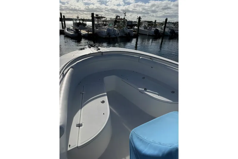 Slide: The Image of 2005 Edgewater 245CC boat interior at marina, featuring spacious seating and calm waters. - 14