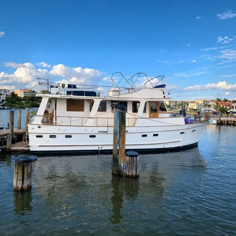 The Image of 1985 Marine Trader 50 yacht docked at marina under blue sky. - 0