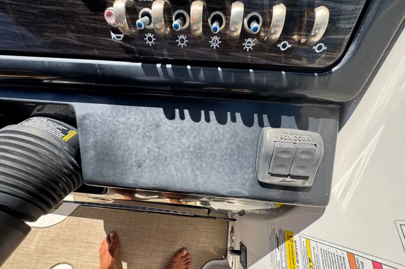 Slide: The Image of Control panel of a 2018 Sea Ray Sundancer 260 boat with switches and foot visible. - 69