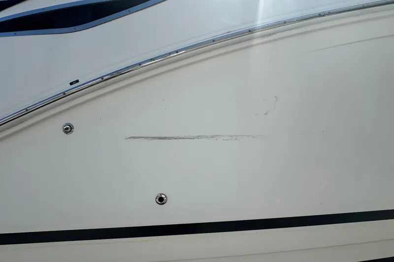 Slide: The Image of 2018 Sea Ray Sundancer 260 boat hull with visible scratch and metal fittings. - 16