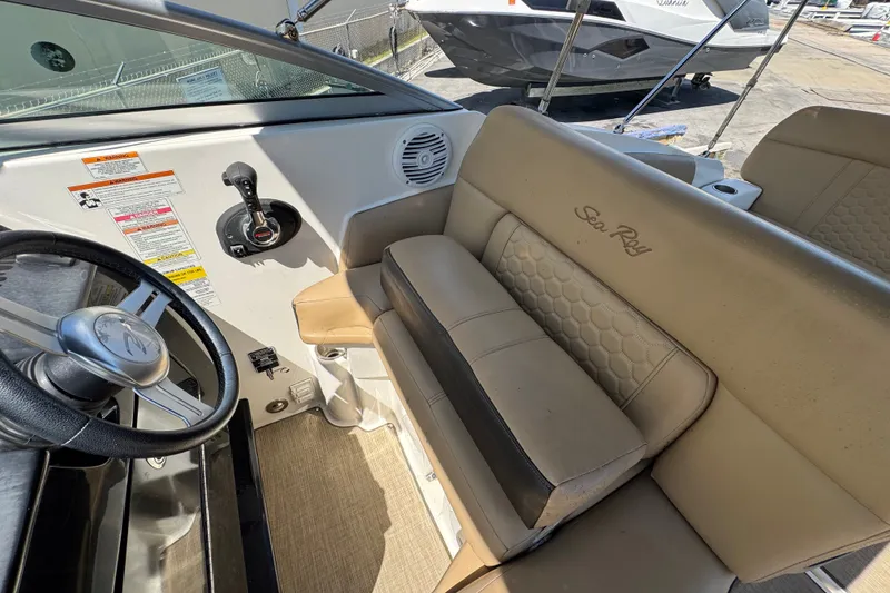 Slide: The Image of 2018 Sea Ray Sundancer 260 cockpit with steering wheel and beige seating. - 27