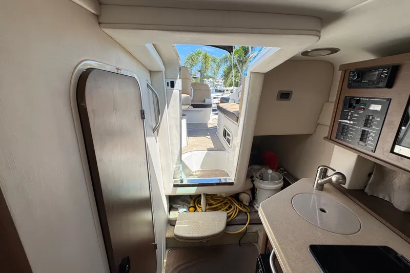 Slide: The Image of Interior view of 2018 Sea Ray Sundancer 260 boat cabin with kitchenette and control panel. - 32