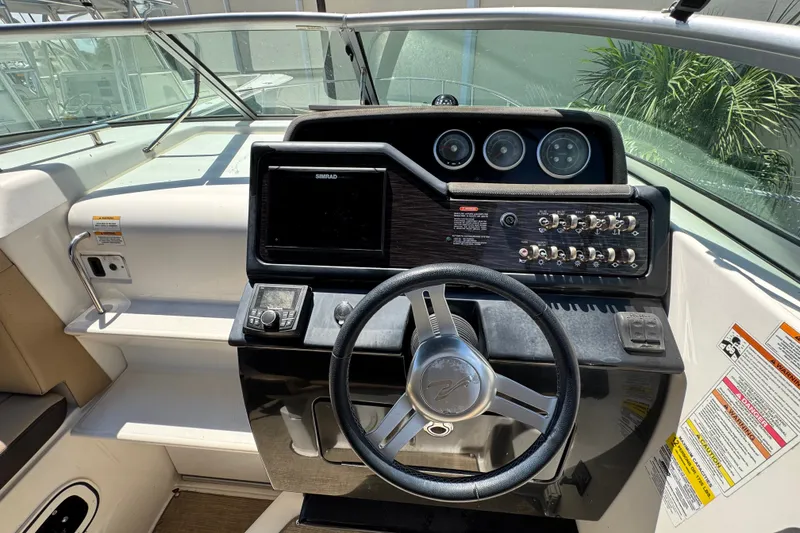 Slide: The Image of Cockpit of 2018 Sea Ray Sundancer 260 with steering wheel and control panel. - 81