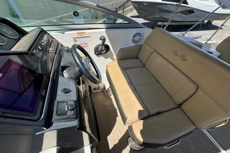 Slide: The Image of 2018 Sea Ray Sundancer 260 helm with beige seating and modern controls. - 53
