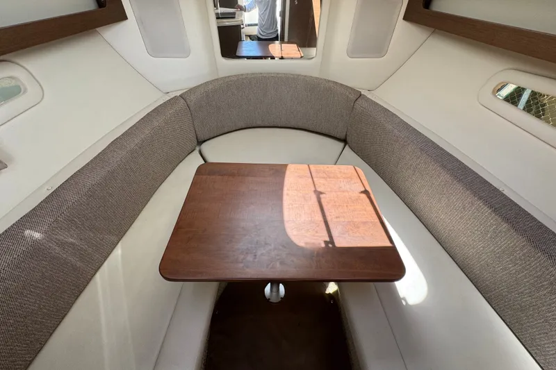 Slide: The Image of Interior of 2018 Sea Ray Sundancer 260, featuring a cozy dining area with wooden table. - 34