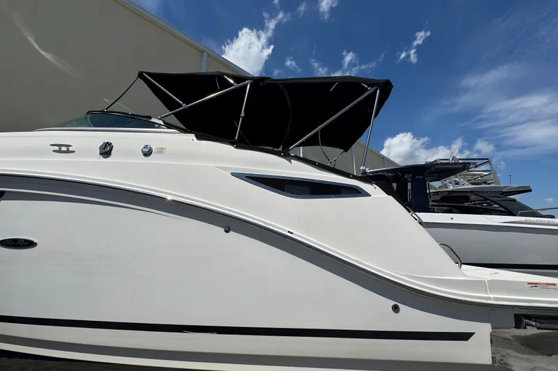 Slide: The Image of 2018 Sea Ray Sundancer 260 boat with black canopy under blue sky. - 9