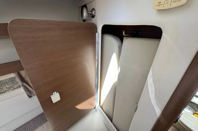 Slide: The Image of Interior cabin of 2018 Sea Ray Sundancer 260, featuring wooden paneling and storage compartment. - 31